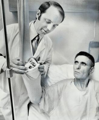 Two severed fingers replaced on his hand, laborer Giuseppe Gallace, 53, is checked by the plastic surgeon, Dr. Ralph Manktelow, yesterday. Gallace had(...)