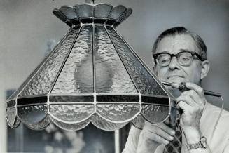 Gerhardt Tehiessen, of Kitchener, puts the finishing touches to the reproduction of a Tiffany lamp he made for the sale