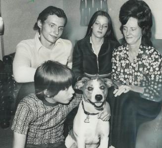 Bozo, a Dog that can't understand that Greg Bott, 13, is missing, sits with members of Greg's family in their home in Regent Park. Allan, 11, is on th(...)