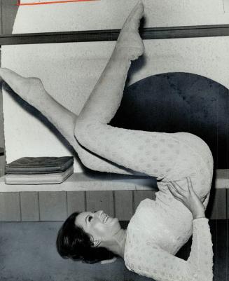 Nancy Fisher is shown doing the bicycle exercise for trimming thighs and legs
