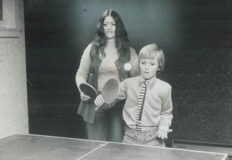 Nanny June Fowler supports Michael Grieve, 9, in a family ping pong game