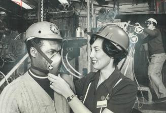 Nurse Donna Brash adjusts face mask for Ralph Meredith, factory worker, Ms Brash is employed by The Company Nurse, a unique business founded by a nurse to provide health care to small factories