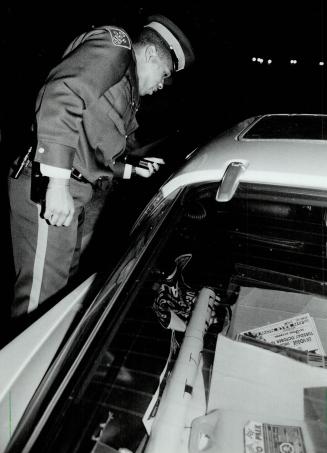 Above, from left, OPP Constables Hugh Croney, Cam Woolley, Andy Gibaut (shown talking to a driver) and Steve Robertson patrol the 401
