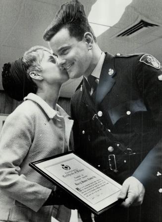 For valor - award, and a kiss, OPP Constable Barry Connelly gets a kiss from his wife today after he became the third man in OPP history to receive t(...)