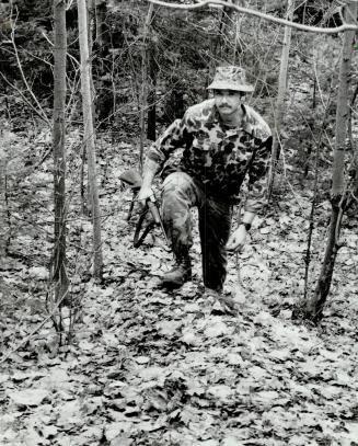 Rough day's work: The dense bush around Huntsville is no place for a novice to wander but this member of the OPP TRU team was one of those who tracked down murder suspect Ralph Morris