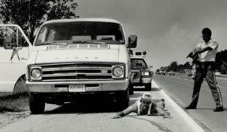 Taking no chances, OPP Constable Dana King trains his gun on Robert Yurko, 29, of Parma Heights, Ohio, after stopping his van on Highway 400 in the Ba(...)