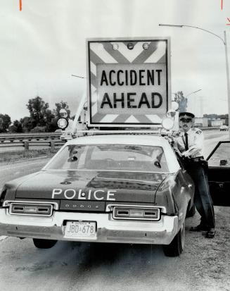 A car-top sign that can be put up in seconds in emergency situations in traffic is demonstrated by Constable Don Landry of the Burlington, Ontario Pro(...)