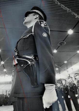 Ten-Shun! Rigid precision of Ontario Provincial Police ceremonial marching unit is shown by William McBurnie of Chatham during inspection yesterday by Commissioner Eric Silk