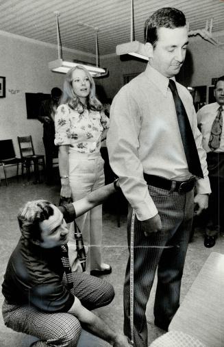 One of the first 16 women to join the Ontario Provincial Police, Nancy Grossmith watches tailor Joe Lorik measure a recruit, Robert South, for his uni(...)