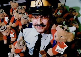 Making life bear-able for kids, RCMP Corporal Greg McGrath is surrounded by new, fuzzy allies - Teddy Bears - for the purpose of helping children at P(...)
