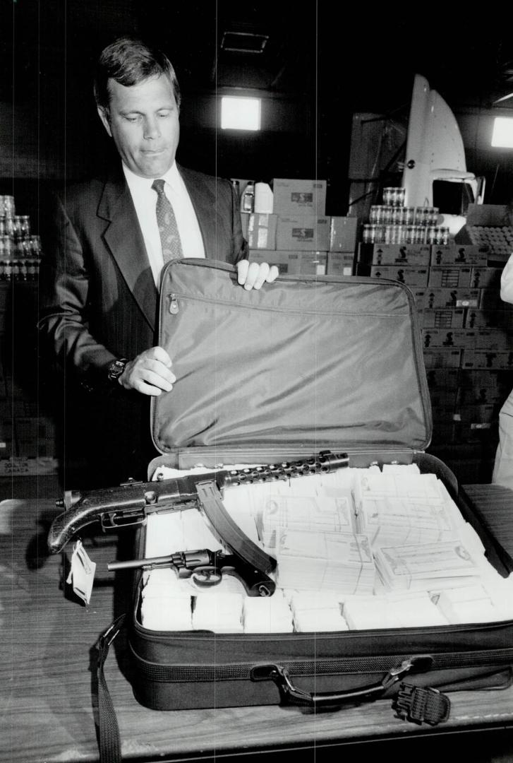 Recovered Goods: Peel Regional Police Inspector Alf Thomas displays some of the stolen property recovered, including a suitcase full of counterfeit travellers cheques, in an undercover operation