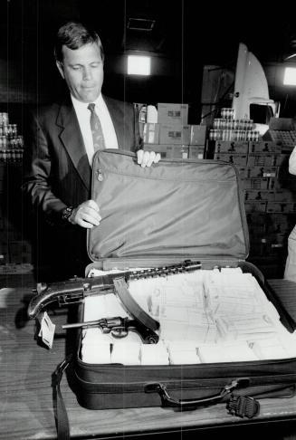 Recovered Goods: Peel Regional Police Inspector Alf Thomas displays some of the stolen property recovered, including a suitcase full of counterfeit travellers cheques, in an undercover operation