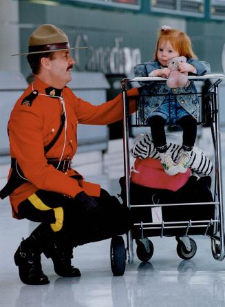 A Mountie always gets his girl, RCMP Constable Roy Luscombe greets a shy Samanthe Waddell, 2, at Pearson International Airport while participating in (...)