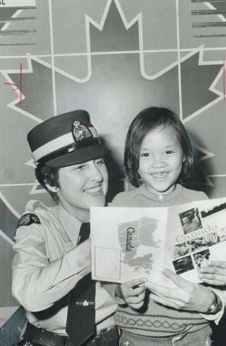 RCMP constable Gail McKeag gives Nguyen Bich an, 8, her first look at Canada