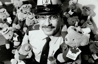 Making life bear-able: RCMP Corporal Greg McGrath is surrounded by the teddy bears officials will use to help children deal with traumas at Pearson Airport