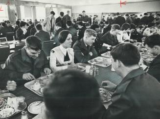 Male and female recruits eat their meals together in the barracks mess hall