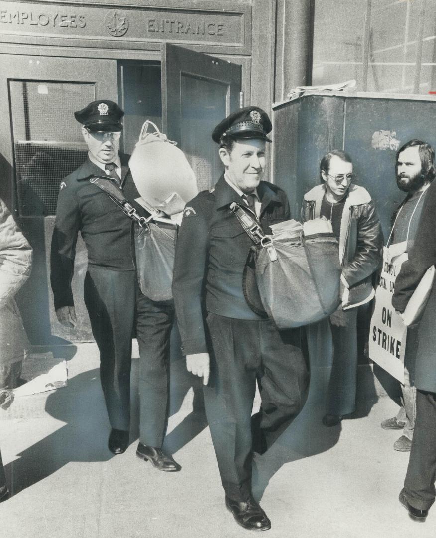 Crossing the picket lines of inside workers, letter-carriers leave the main postal station on Bay St