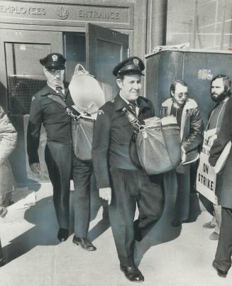 Crossing the picket lines of inside workers, letter-carriers leave the main postal station on Bay St