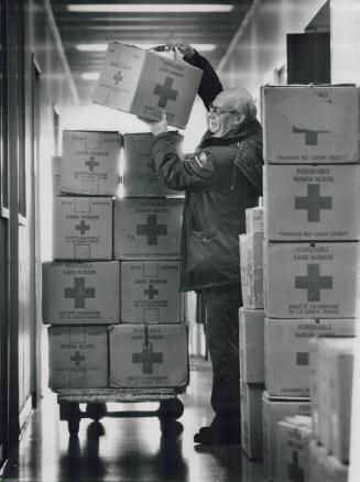 Ted Blanchett, left, stacks boxes of blood products ready to be shipped to one of the 60 hospitals served by the Toronto Blood Centre of the Canadian Red Cross