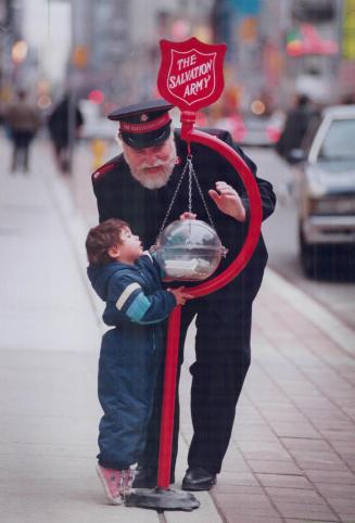 Major Robert MacKenzie helps Leanna Hunt, 3, make a donation as the Salvation Army launches its Christmas Kettle Appeal campaign yesterday. The Army e(...)