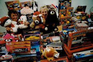 Santa's pals: Sharron Millard, left, and Gloria Brown, with the Mississauga Salvation Army, peek out from an array of toys which will go to needy children