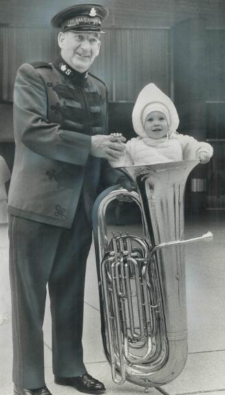 Salvation army bandsman George Russell, during a lull in a concert on Nathan Phillips Square this weekend, stuffs his granddaughter Michelle Russell, (...)