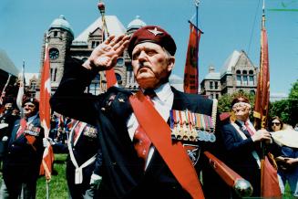 Salutes and boos, Bruce Cox, 67, salutes yesterday at Queen's Park during Victoria Day ceremonies