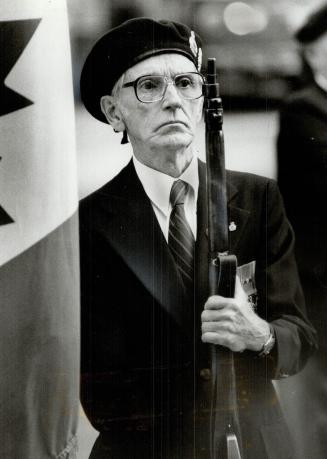 D-Day memories: Jim Kenn, 70, a member of the Royal Canadian Legion color party at D-Day ceemonies at the old city hall Cenotaph today, presents arms during the salute