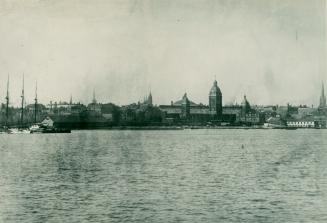 Image shows a lake view with some buildings in the background.