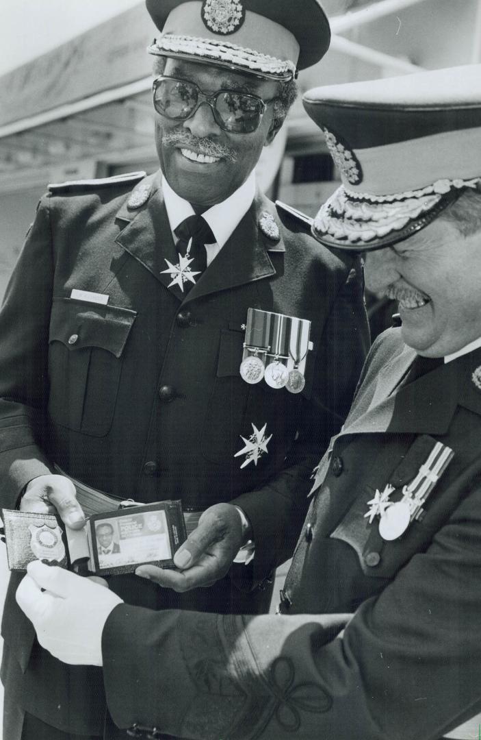 Forceful credentials, Lincoln Alexander, Ontario's retiring Lieutenant-Governor, Shows OPP Commission Thomas O'Grady the ID card and badge he received(...)