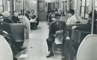 Citizen William Allen reads his paper on the subway on his way to work