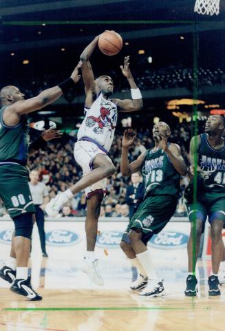 Man the middle: Toronto's Willie Anderson drives to the hoop between Milwaukee's Kevin Duckworth, left, and Glenn Robinson at SkyDome last night