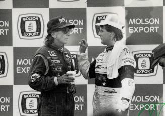 Michael Andretti apologizes to Emmerson Fittipaldi, left, on the victory podium after pushing the Brazilian star into a wall in the final moments of y(...)