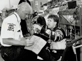 Checking in: Michael Andretti talks strategy with his pit crew during yestrerday's opening qualifying session for tomorrow's fifth Molson Indy