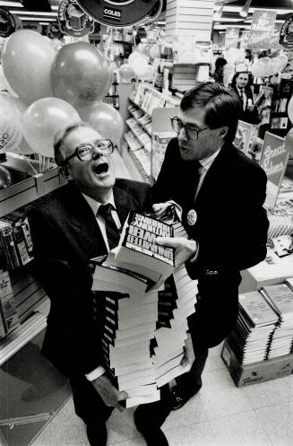 Booked up for Anniversary. Ernie Kostal, left, manager of the Coles bookstore at Yonge and Charles Sts. for 31 years, gets a hand from Coles president(...)