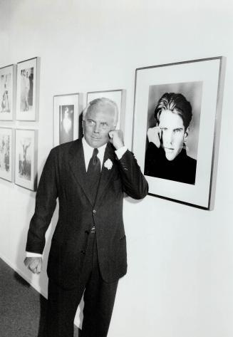 Italian Designer. Giorgio Armani, right mimics a photofrom his fall/winter '87 collection, part of the retrospective at the Fashion Institute of Technology in New York