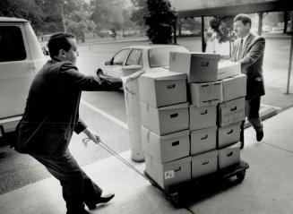Search for evidence: Metro Constable James Lowry, left, and Staff-Sergeant Wayne Cotgreave wheel boxes of files removed from Gordon Ashworth's office