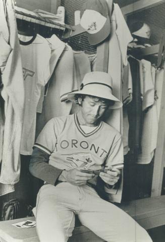 Blue Jays' outfielder Bob Bailor peruses this year's baseball cards