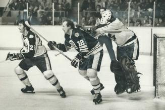 Leaf goalie Paul Harrison uses Bruins' Wayne Cashman as his jumping-off point in bid to get a better view of the action