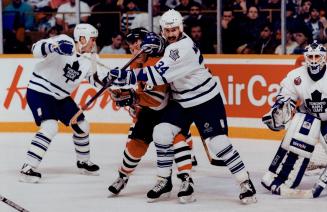 Close encounter: Leafs defenceman Jamie Macoun and Hawks right winger Steve Larmer Jostle in last night's tussie at Maple Leaf Gardens