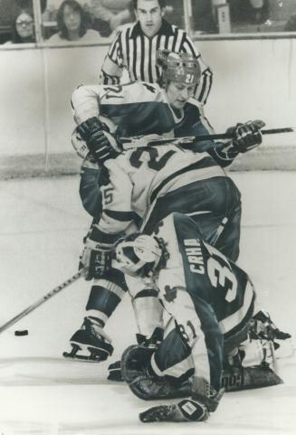 Well covered: Defenceman Borje Salming of Leafs wasn't too gentle as he applied his arm and stick to stop North Stars' Al MacAdam from getting puck in front of goalie Jiri Crha
