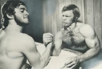 Muscles bulge as Bobby Hull (right) arm wrestles with Gilles Gratton, a backup Goalie with team Canada