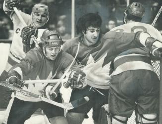 Maple leafs' Paul Henderson, left foreground, with helmet, and Montral's Guy Lapointe must've thought they were in woods as they battled in front of S(...)