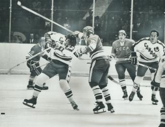 At right, a Russian player appears to be combing a Canadian's head with his stick