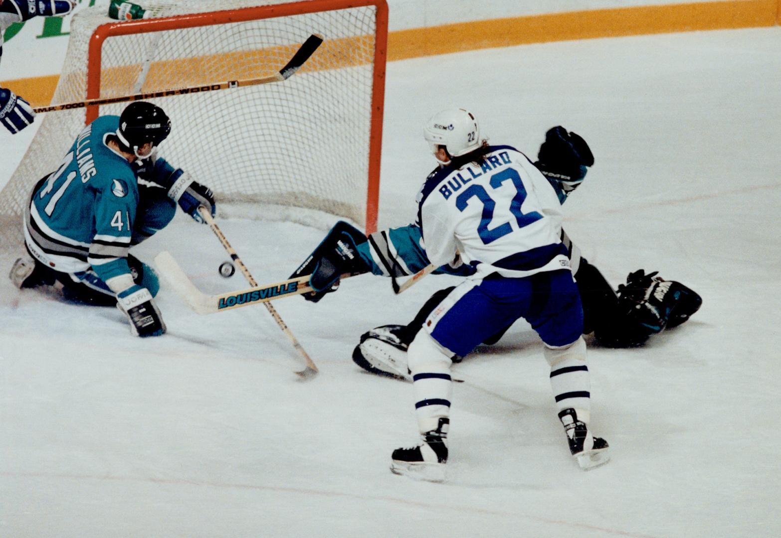 Missed opportunity: Leaf centre Mike Bullard chases a puck at the San Jose net as defenceman David Williams, left, and goalie Jeff Hackett scramble during the first period last night at the Gardens