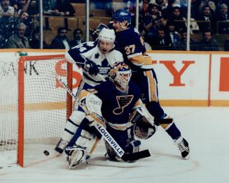 Heavy traffic: Maple Leafs' Dave Reid crashes the crease while Blues defenceman Robert Dirk hangs on and goalie Curtis Joseph is beaten by the puck