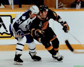 Shoulder to shoulder: Leaf defenceman Michel Petit tries to restrain Trevor Linden, whose shorthanded goal gave the Canucks a 2-1 win at Gardens