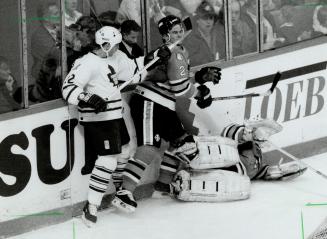 Stick sandwich: Leafs' Ken Baumgartner gives defenceman Rob Zettler of the Sharks a mouthful of lumber after knocking goalie Arturs Irbe to the ice