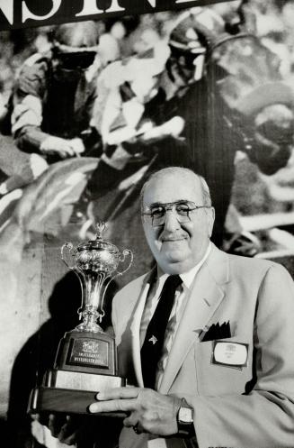 Rich bauble: Sam Rubin, a New York bicycle importer, holds the Rothmans Cup he'd like to add to the well-stocked trophy case belonging to his 9-year-old gelding John Henry