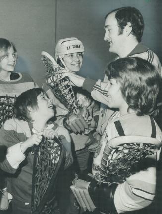 Lacrosse forward Kim Sutherland, 11, (in helmet) and other girl lacrosse players get advice from Mike McMahon, one of two physical-education teachers (...)